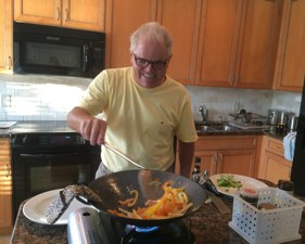 Bill having fun cooking in his "Eleanor Hoh Wok Star System" (love this) on their kitchen island!