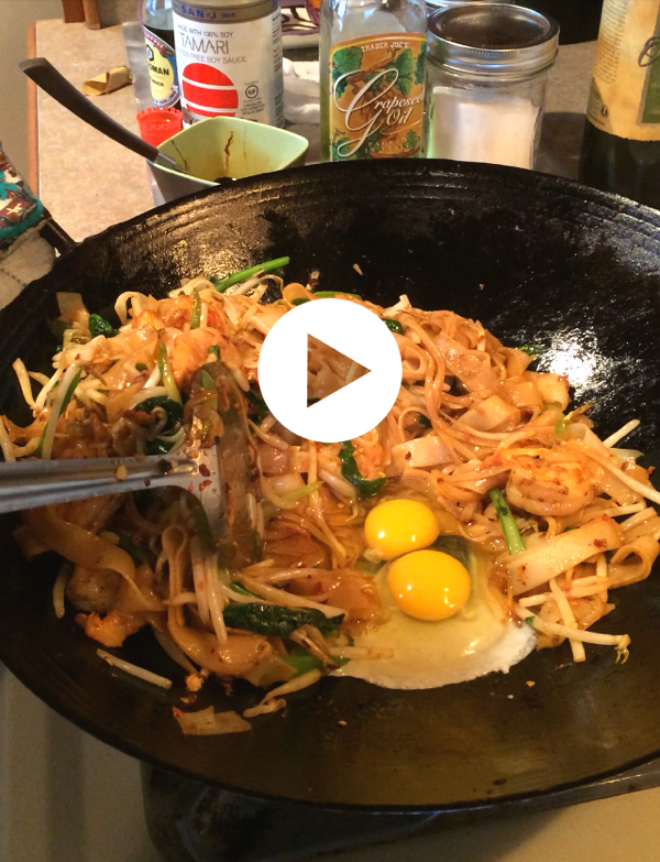 7. Push noodles to one side and add drop 2 eggs into wok, cover the eggs with noodles to cook them a bit. Then frantically start stir frying everything so the eggs get to cook through into yummy chunks and coat the noodles. 