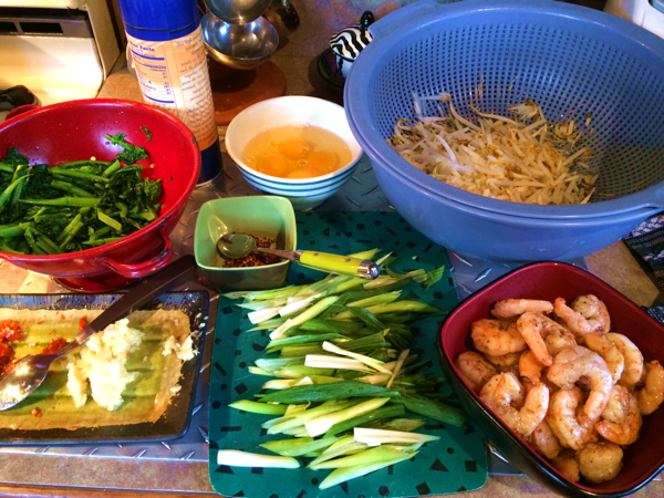 1. Prep of Kuey Teow ingredients, top left to right: blanched rappini (sub for choy sum), 4 eggs, bean sprouts, ready fried shrimp, scallions, chopped garlic, diced red chilies, dried chili flakes, 